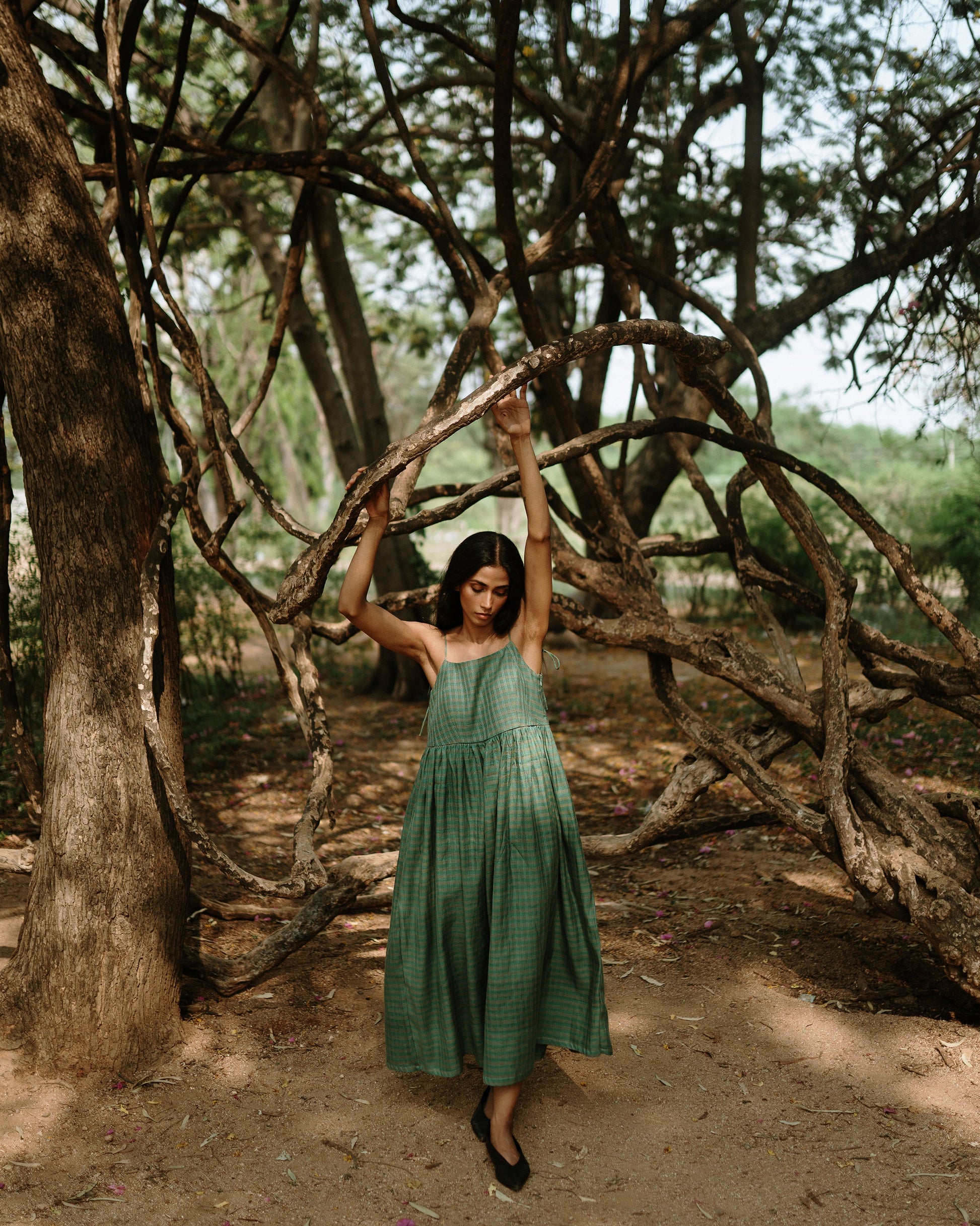 Plains Design - River mulberry silk cotton dress. Sleeveless midi dress with spaghetti straps, and a gathered waist in a green cotton mulberry silk fabric with red and white checks. Ethically handmade and handspun in India.