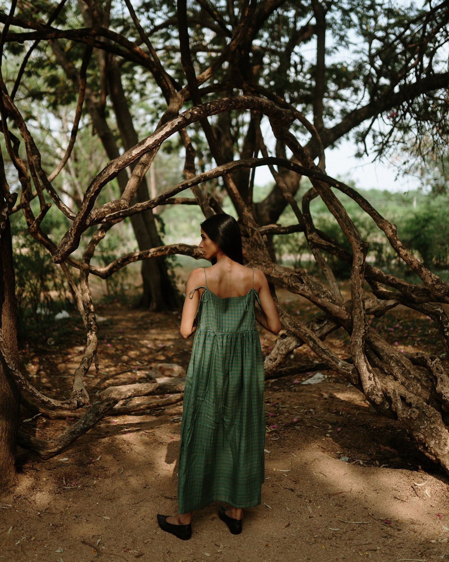 Plains Design - River mulberry silk cotton dress. Sleeveless midi dress with spaghetti straps, and a gathered waist in a green cotton mulberry silk fabric with red and white checks. Ethically handmade and handspun in India.