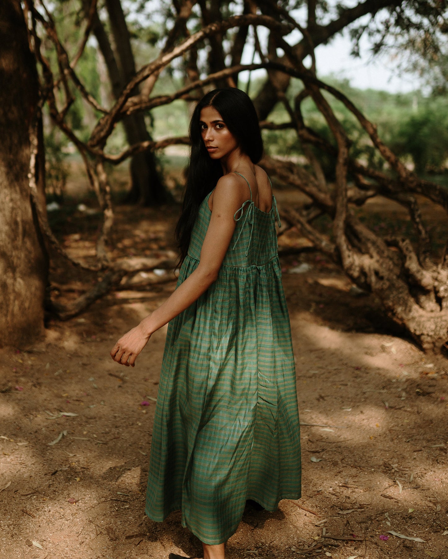 Plains Design - River mulberry silk cotton dress. Sleeveless midi dress with spaghetti straps, and a gathered waist in a green cotton mulberry silk fabric with red and white checks. Ethically handmade and handspun in India.