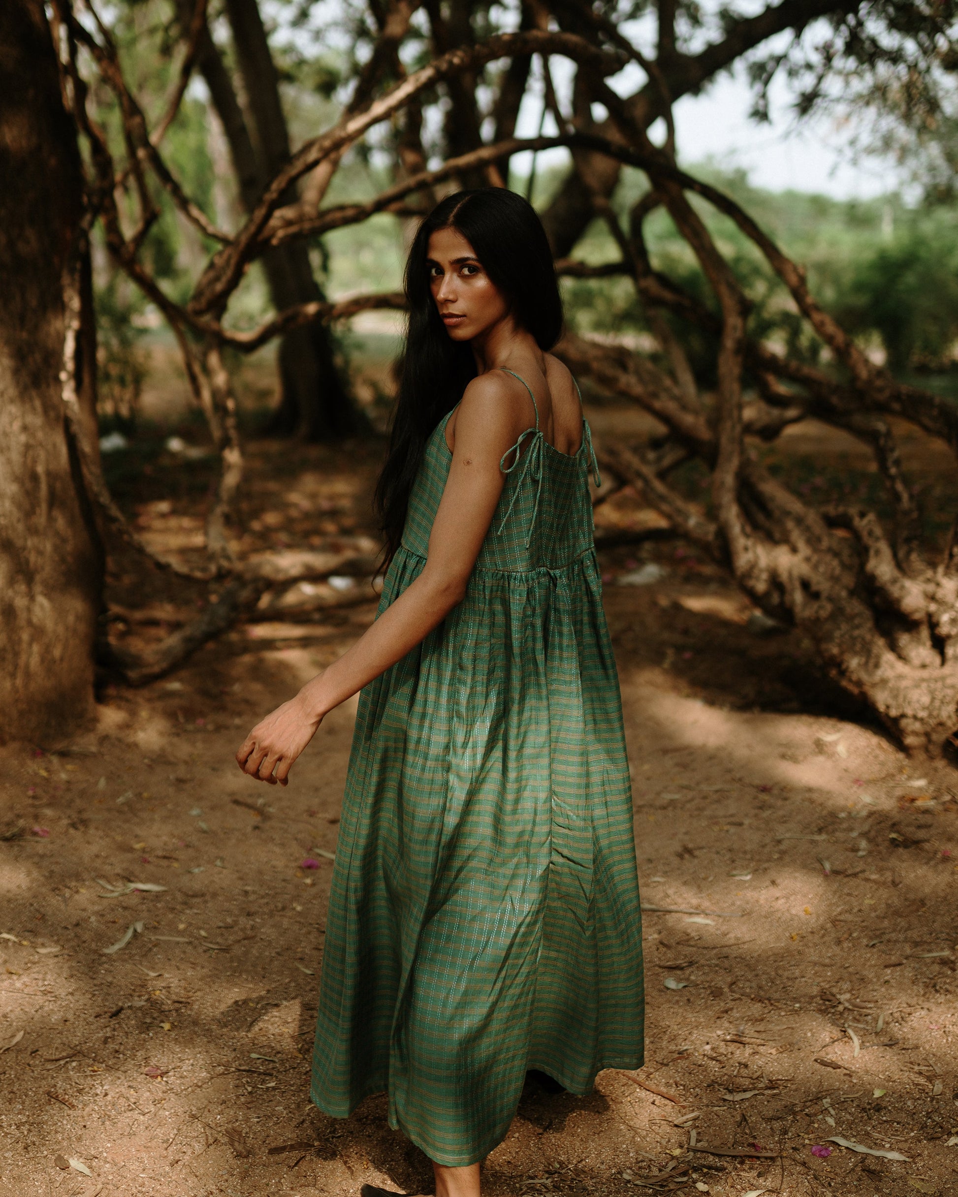 Plains Design - River mulberry silk cotton dress. Sleeveless midi dress with spaghetti straps, and a gathered waist in a green cotton mulberry silk fabric with red and white checks. Ethically handmade and handspun in India.