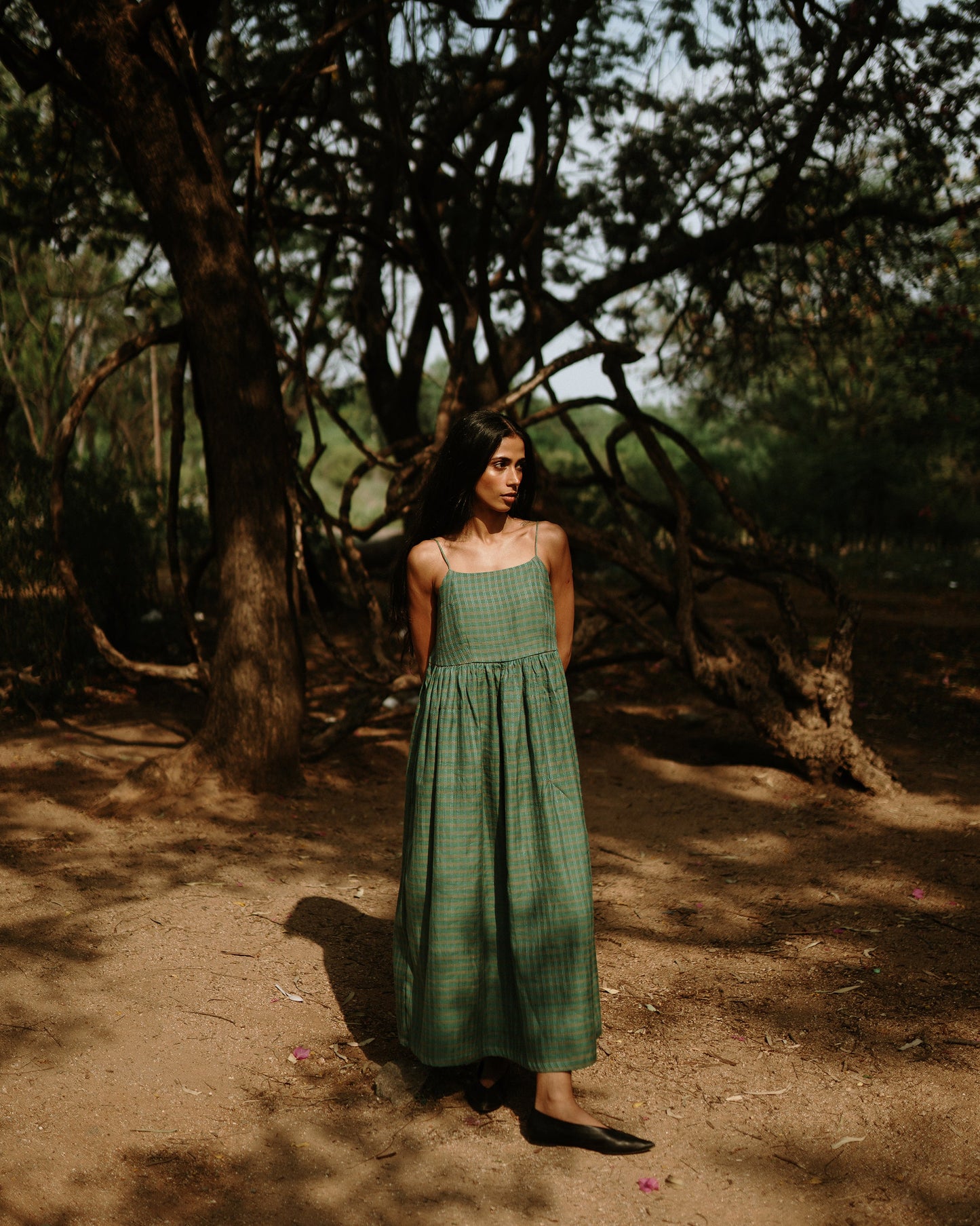 Plains Design - River mulberry silk cotton dress. Sleeveless midi dress with spaghetti straps, and a gathered waist in a green cotton mulberry silk fabric with red and white checks. Ethically handmade and handspun in India.