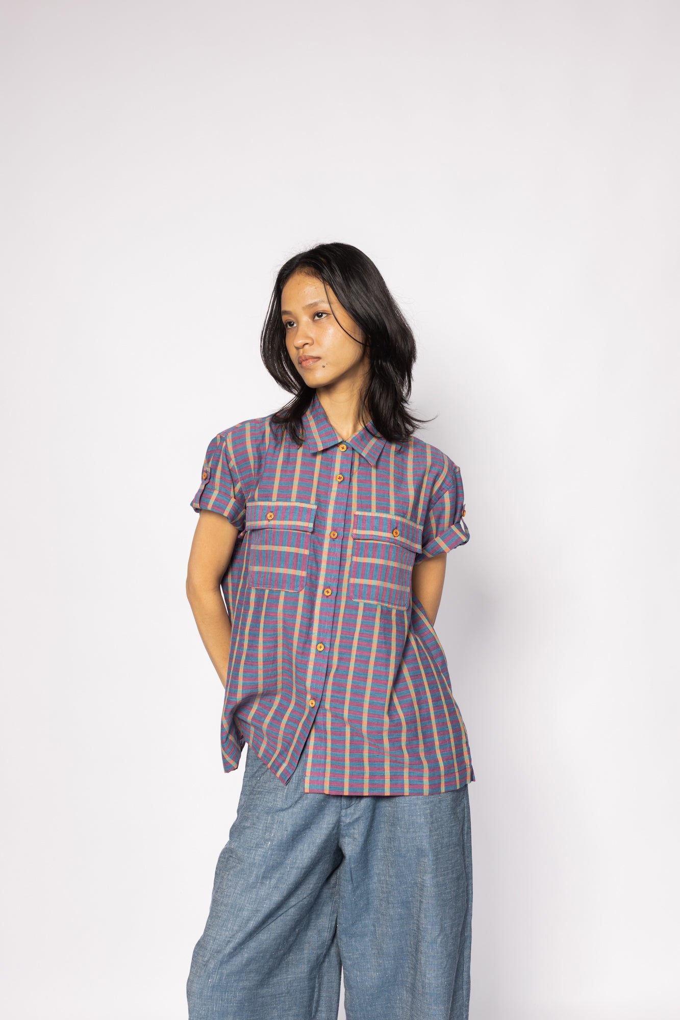 Plains Design - Twin Shirt in Purple. Striped purple and blue button-up shirt with short folded sleeves, chest pockets, wooden buttons and collar. Paired with blue denim pants. Handmade cotton. Ethical fashion.